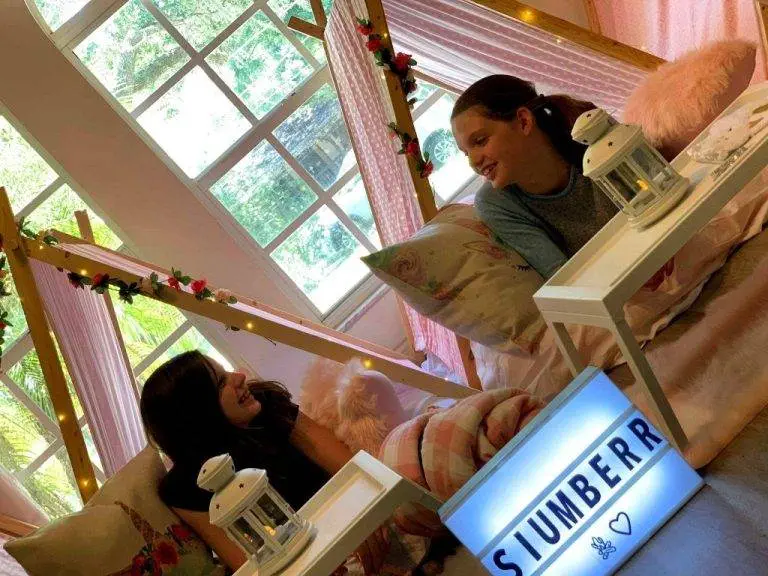 2 teenage girls sitting in teepees having a slumber party.