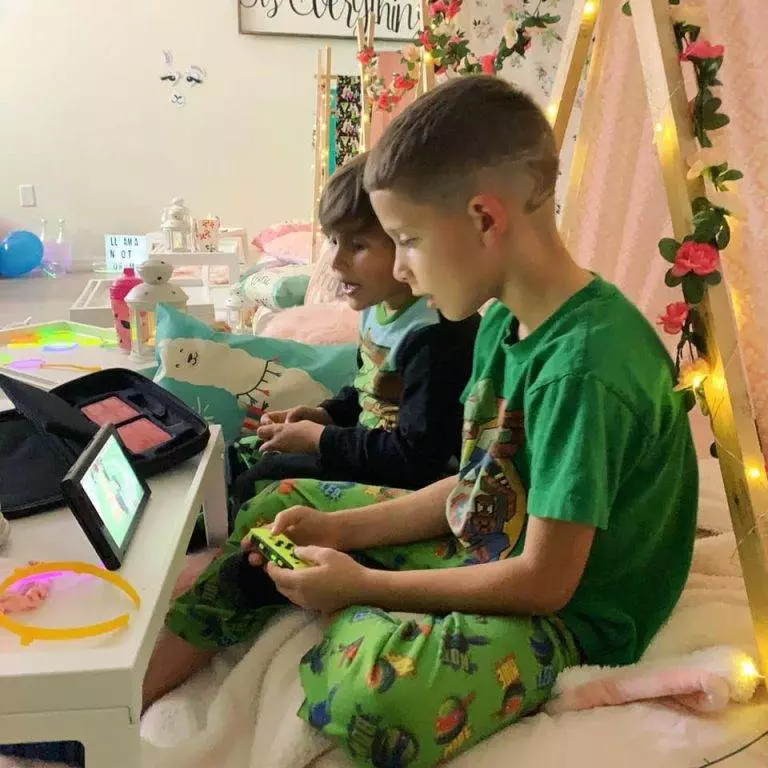boy playing video game at a llama themed teepee party rental