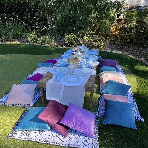 Decorative custom picnic table with pillows surrounding.